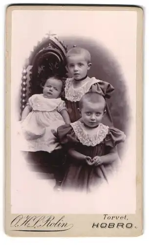 Fotografie O. H. L. Rolin, Hobro, Torvet, Zwei Kinder in Rüschenkleidern und Täufling auf einem Stuhl