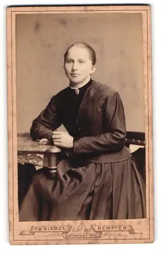 Fotografie F. X. Siegel, Kempten, Kotterner-Strasse, Junge Dame im schwarzen Kleid am Tisch