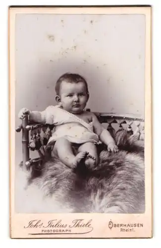Fotografie Johs. Julius Thiele, Oberhausen i. Rheinland, Friedrich Carlstrasse 32, Baby auf einem Fell