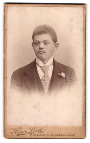 Fotografie Hans Luck, Düsseldorf, Bismarckstrasse 85, Junger Mann mit Krawatte im Anzug und Blume am Revers