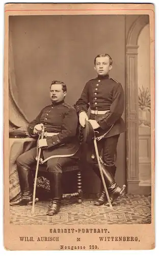 Fotografie Wilh. Aurisch, Wittenberg, Neugasse 259, zwei Einjährig-Freiwillige Soldaten in Uniform mit Säbel, Sporen