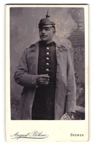 Fotografie August Böhne, Bremen, preussischer Soldat in Uniform mit Mantel und alter Picklehaube