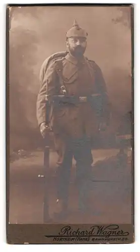 Fotografie Richard Wagner, Northeim, Soldat in Feldgrau Uniform mit Pickelhaube Tarnbezug und Ausmarschgepäck