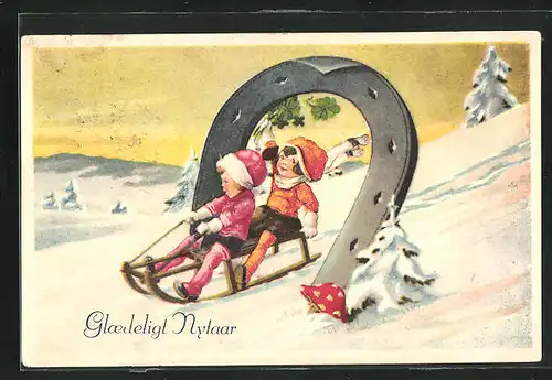 AK Kinderpaar fährt mit Schlitten durch ein Hufeisen, Neujahrsgruss
