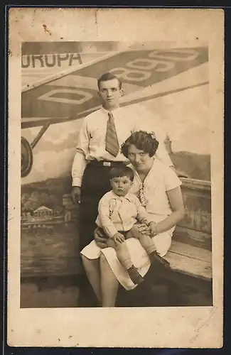 Foto-AK Familie in Studiokulisse mit Flieger