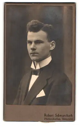 Fotografie Robert Schwarzbach, Bitterfeld, Junger Mann mit Seitenscheitel im schwarzen Anzug mit Fliege