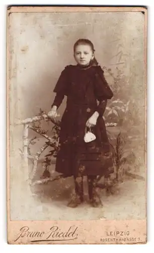 Fotografie Bruno Riedel, Leipzig, Rosenthalgasse 9, Junges Mädchen in schwarzem Kleid mit kleiner Tasche und Halskette