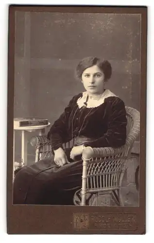 Fotografie Rudolf Müller, Rochlitz, Junge Dame in schwarzem Kleid mit langer Halskette und ernstem Blick