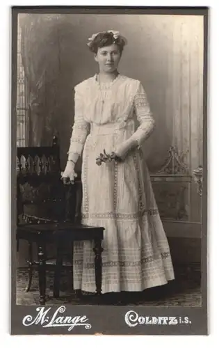 Fotografie M. Lange, Colditz i. S., Junge Dame in weissem Kleid mit langer Kette und Handschuhen