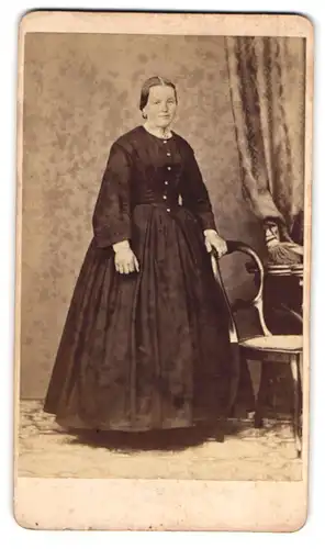 Fotografie L. Strobel, Kempten, Am Graben 143, Beleibte Dame im weiten schwarzen Kleid mit leichtem Lächeln