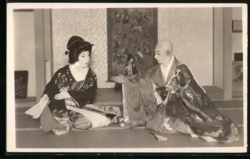 Fotografie Japan, Geisha im Kimono mit Fächer sitzt ihrem Herren gegenüber