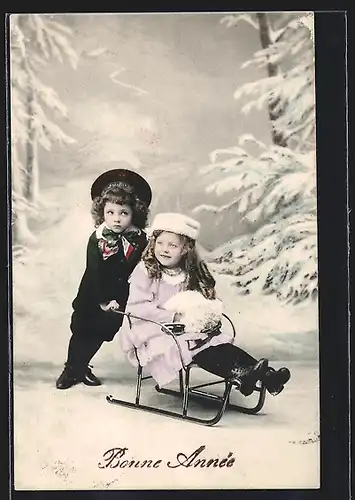 AK Kleiner Junge schiebt einen Schlitten im Schnee