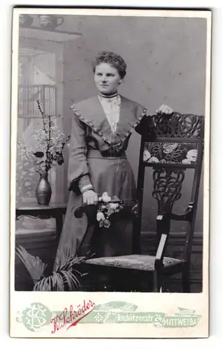 Fotografie K. Schröder, Mittweida, Portrait wunderschöne junge Frau mit Blumen in der Hand am Stuhl stehend
