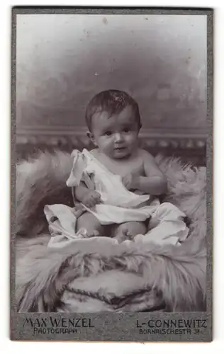 Fotografie Max Wenzel, L-Connewitz, Portrait süsses Kleinkind im weissen Hemd auf Fell sitzend