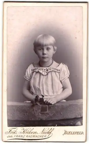 Fotografie Fritz Küken Nachf., Bielefeld, Portrait hübsch gekleidetes Mädchen mit Blumen in der Hand