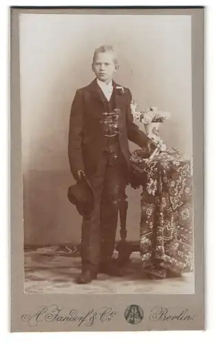 Fotografie A. Jandorf, Berlin, junger Mann neben Vase stehend