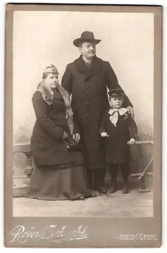 Fotografie Robert Schucht, Seefeld-Zürich, Portrait winterlich gekleidetes Paar mit einem kleinen Sohn