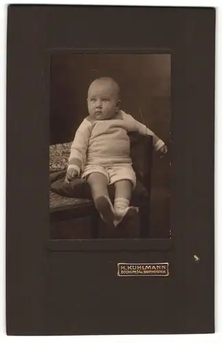 Fotografie H. Kuhlmann, Bochum i / W., Portrait niedliches Kleinkind in hübscher Kleidung auf Kissen sitzend