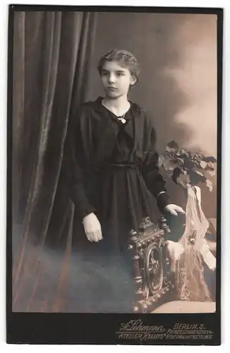Fotografie A. Lehmann, Berlin-S, Portrait junge Dame im schwarzen Kleid mit Buch an Tisch gelehnt