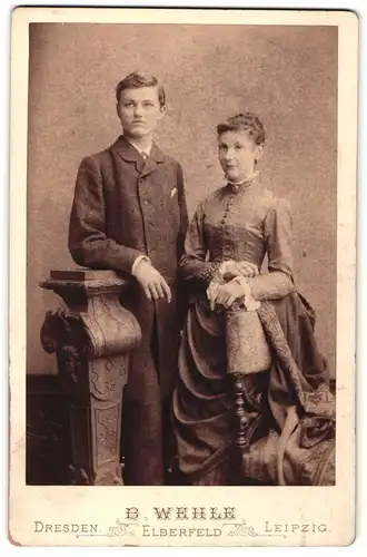 Fotografie B. Wehle, Dresden, Portrait hübsches Paar in eleganter Kleidung an Sockel gelehnt