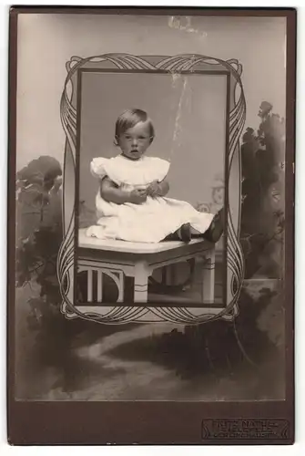 Fotografie Fritz Matull, Bielefeld, Portrait kleines Mädchen im weissen Kleid auf Tisch sitzend