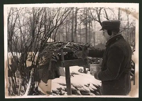 Fotografie Vogelfreund versorgt Vögel mit Hanffutter im Winter 1941