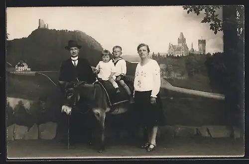 Foto-AK Kleine Familie beim Familienfoto vor Studiokulisse, Kinder auf einem Esel