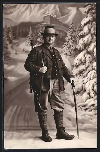 Foto-AK Jäger mit Flinte vor Studiokulisse einer Berglandschaft