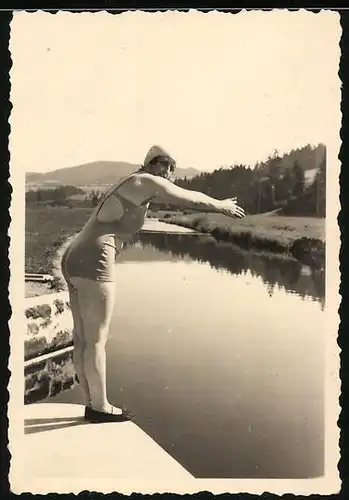 Fotografie Hausfrau im badeanzug mit Badekappe springt von einer Ufermauer