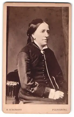 Fotografie H. Schumann, Flensburg, Portrait hübsche Dame mit Brosche im Kleid