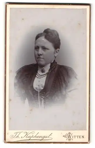 Fotografie Th. Kaphengst, Witten, Portrait bildhübsche Dame mit Dutt, Brosche und Halskette