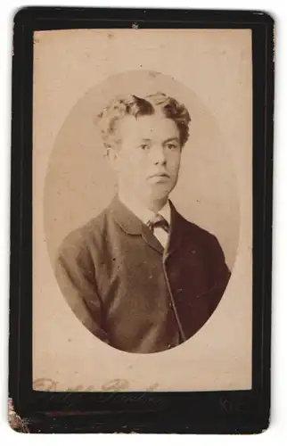 Fotografie Detlef Paulsen, Kiel, Portrait junger Mann mit lockigem Haar im Anzug