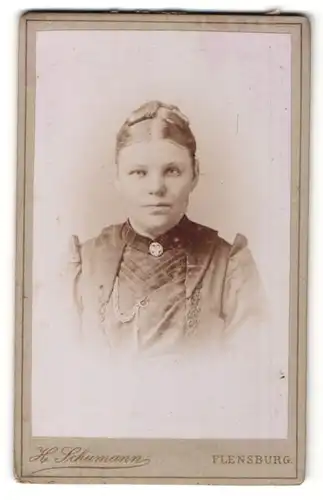 Fotografie H. Schumann, Flensburg, Portrait schöne junge Frau mit Dutt und Brosche am Kragen