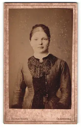 Fotografie J. Mackeprang, Oldenburg, Portrait junge Dame im eleganten Kleid mit Kragenbrosche