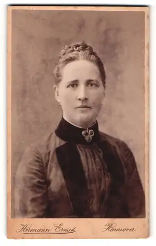 Fotografie Hermann Ernst, Hannover, Portrait bürgerliche Dame mit Flechtfrisur und Kragenbrosche
