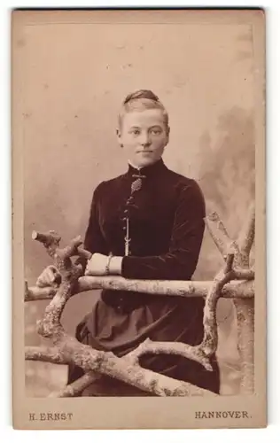 Fotografie E. Ernst, Hannover, Portrait junge Dame in einer Samtbluse am Zaun lehnend