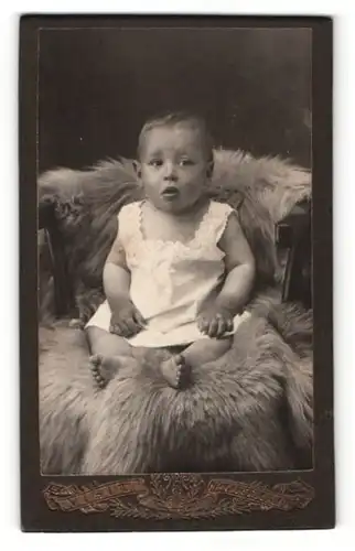 Fotografie M. Rutschmann, Rotthalmünster, Visit-Portrait süsses Kleinkind im weissen Hemd auf Fell sitzend