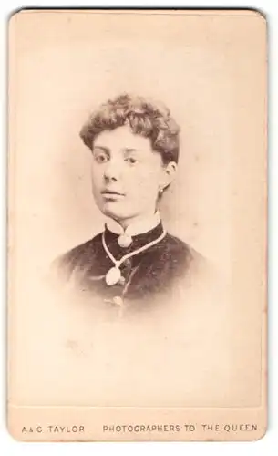 Fotografie A. & G. Taylor, London, Portrait junge Frau mit lockigem Haar, Halskette und Brosche am Kragen