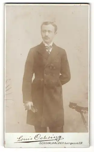 Fotografie Louis Oehrring, Schmalkalden, Portrait charmanter Herr in eleganter Kleidung mit Handschuhen