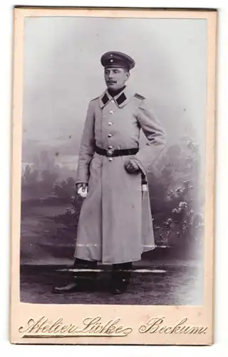 Fotografie Atelier Lütke, Beckum, Portrait Soldat im Uniformmantel mit Schirmmütze