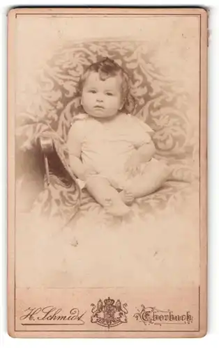 Fotografie H. Schmidt, Eberbach, Portrait niedliches Kleinkind im weissen Hemd auf Decke sitzend