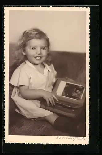 AK Lachendes Mädchen mit einem Ansichtskarten-Album