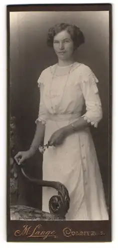 Fotografie M. Lange, Colditz i. S., Junge Dame in weissem Kleid mit Armreif und weisser Rose