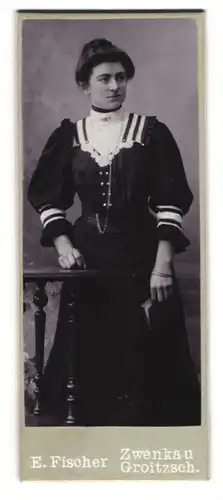 Fotografie E. Fischer, Zwenkau, Dame in schwarzem Kleid mit weissem Kragen mit Schmuck und Buch