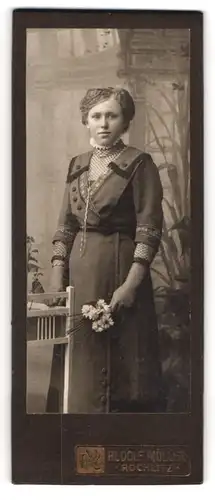 Fotografie Rudolf Müller, Rochlitz, Junge Dame in dunklem Kleid mit weissen Blumen und kariertem Unterkleid