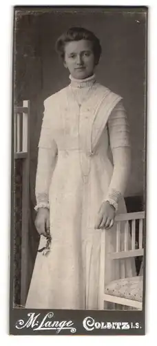Fotografie M. Lange, Colditz i. S., Junge Frau in weissem Kleid lächelt mit müden Augen