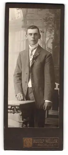 Fotografie Rudolf Müller, Rochlitz, Junger Mann mit runden Ohren im Anzug mit Krawatte und Ansteckblume