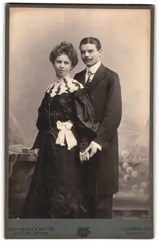 Fotografie Dietrich & Witte, Chemnitz, Poststr. 31, Bürgerliches Paar in schwarzer Kleidung halten sich bei der Hand