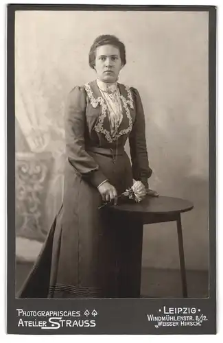 Fotografie Atelier Strauss, Leipzig, Windmühlenstr. 8, Junge Dame in dunklem Kleid mit weisser Blume und Halskette