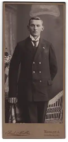 Fotografie Rud. Müller, Rochlitz i. S., Junger Mann mit Segelohren in dunklem Anzug und Krawatte